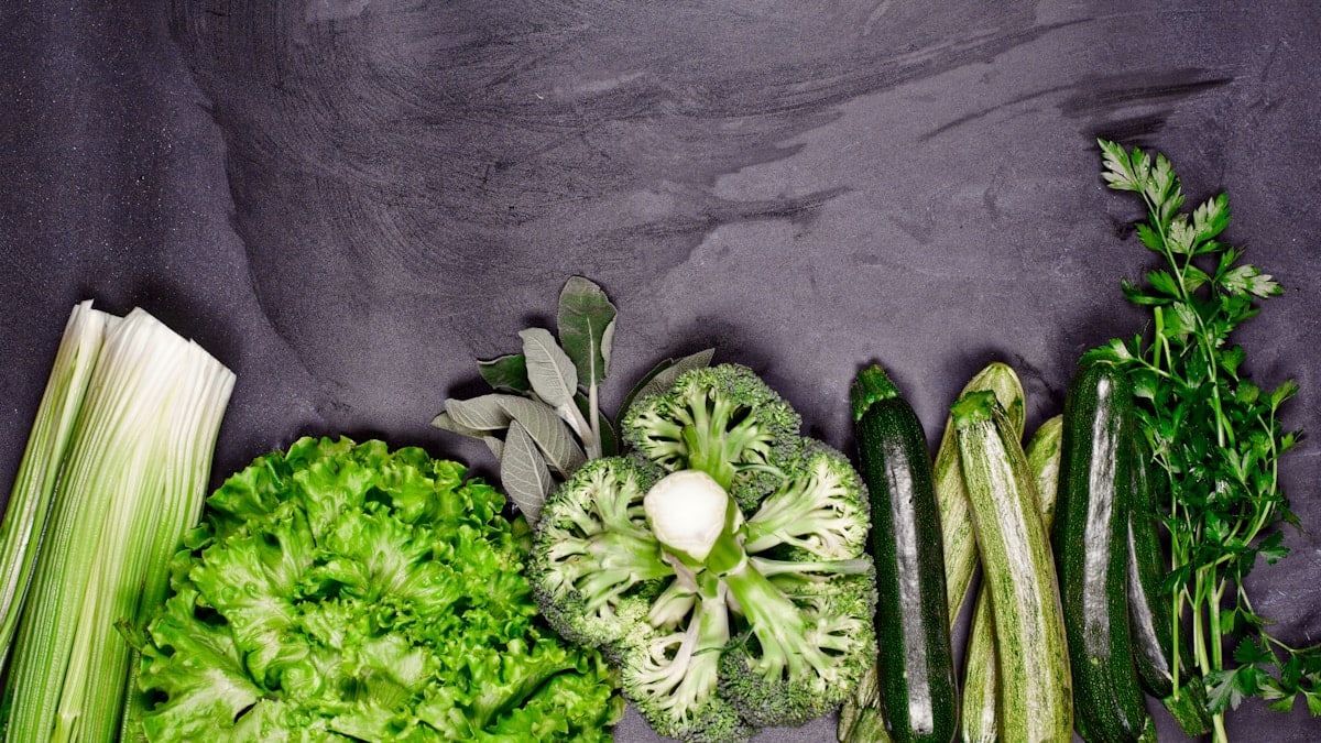 Broccoli, celery, and celery stalks laid out on